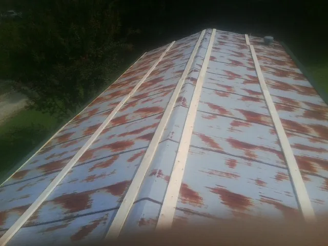 Rusted metal roof panels with new wood purlins before replacement — Storm Damage Roof Repair in Greencreek by Roofing Brothers