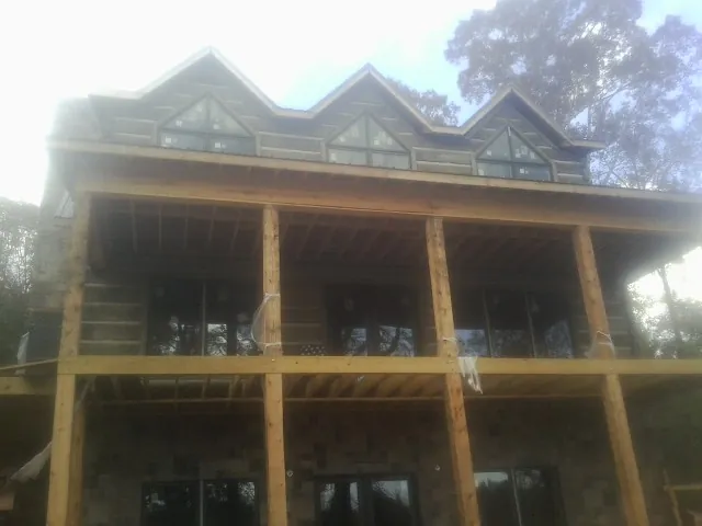 Dormers and porch framing on a large log home under construction — Roof Coating work by our crew in Greencreek