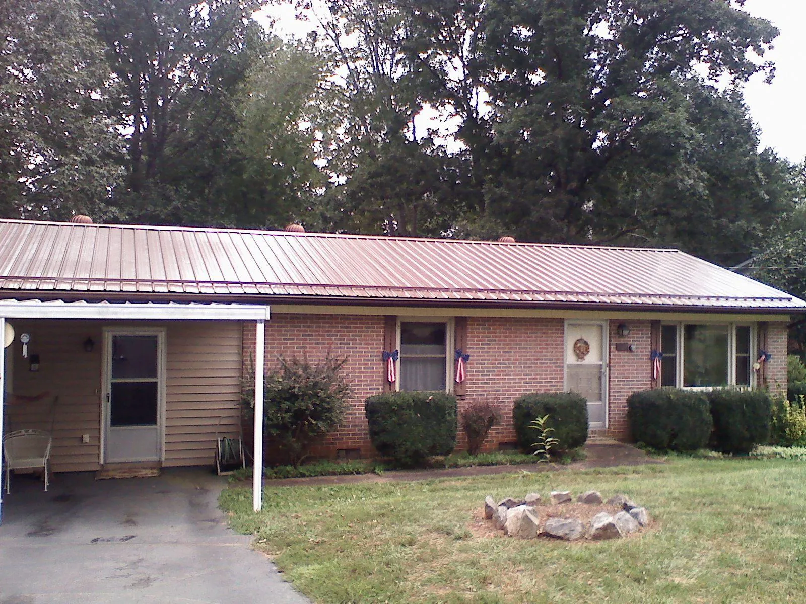 Bronze metal roof and carport on a brick ranch home — Roof Repair work by our crew in Greencreek
